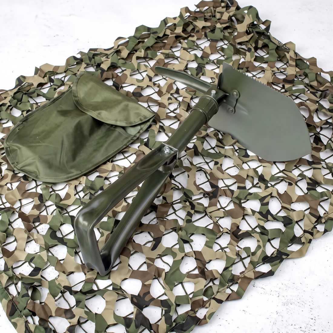 Militär-Klappspaten in Olivgrün mit Transporttasche auf Tarnnetz für Outdoor und Camping