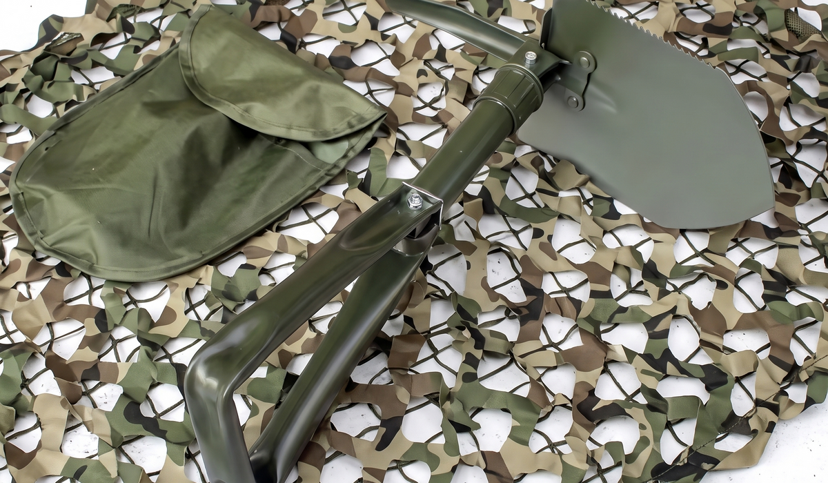 Militär-Klappspaten in Olivgrün mit Transporttasche auf Tarnnetz für Outdoor und Camping