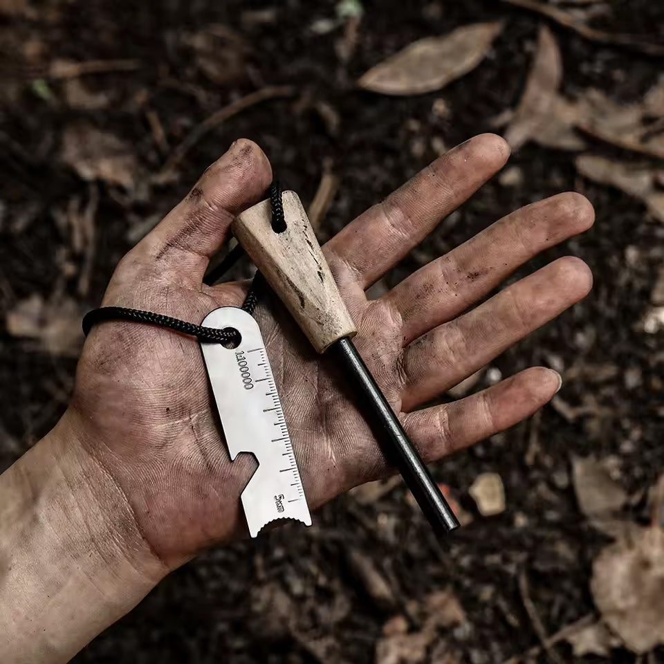 Feuerstahl mit Holzgriff und Metall-Schaber liegt in einer schmutzigen Hand im Wald für ein Survival-Abenteuer.