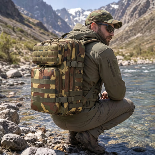 Mann kniend an einem Gebirgsbach mit dem 50L Armee Rucksack mit Tarnmuster vom Army Shop Schweiz